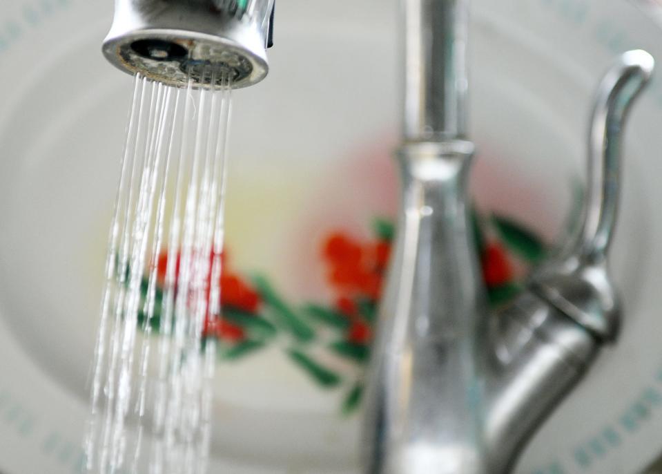 Water pours from a faucet from a kitchen sink.