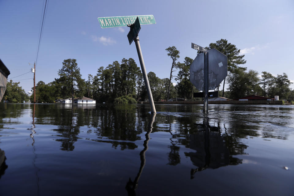 Street signs protrude through floodwaters in the aftermath of Hurricane Florence in Nichols, S.C., Friday, Sept. 21, 2018. Virtually the entire town is flooded and inaccessible except by boat, just two years after it was flooded by Hurricane Matthew. (AP Photo/Gerald Herbert)
