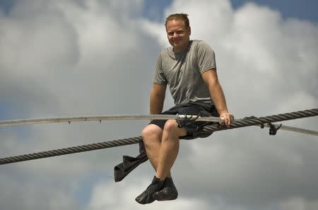 High wire walker Nik Wallenda talks with spectators as he balances on a 1,200 foot-long (366 meter) cable during a practice session in Sarasota, Florida, June 14, 2013. REUTERS/Steve Nesius