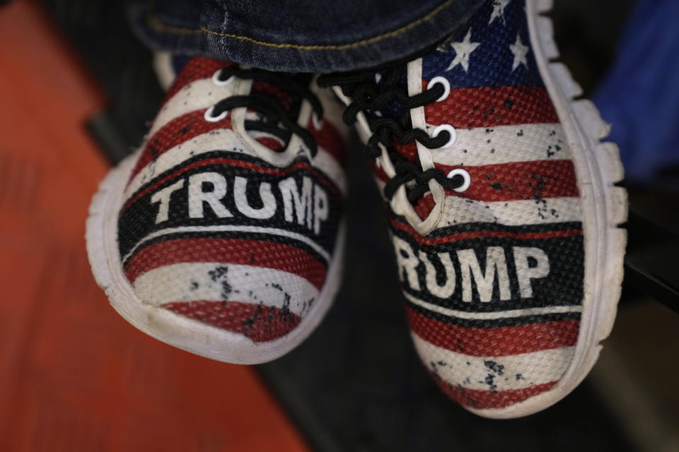 An audience member's shoes are seen during a former President Donald Trump commit to caucus rally, Wednesday, Dec. 13, 2023, in Coralville, Iowa. (AP Photo/Charlie Neibergall)