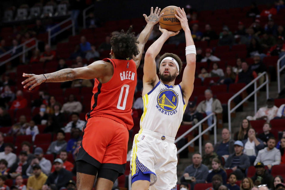 Golden State Warriors guard Klay Thompson (11) puts up a shot as Houston Rockets guard Jalen Green (0) defends during the first half of an NBA basketball game Monday, Jan. 31, 2022, in Houston. (AP Photo/Michael Wyke)