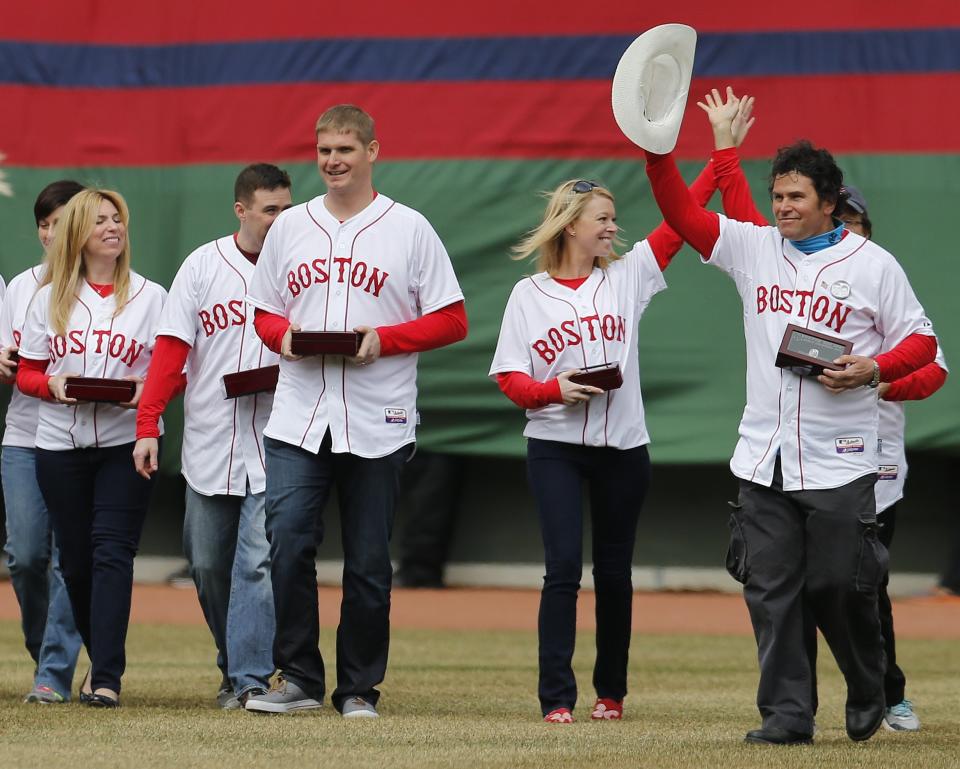 Boston Marathon bombing survivors walk on the field during pre-game ceremonies for a baseball game between the Boston Red Sox and the Milwaukee Brewers on Opening Day at Fenway Park in Boston, Friday, April 4, 2014. (AP Photo/Michael Dwyer)