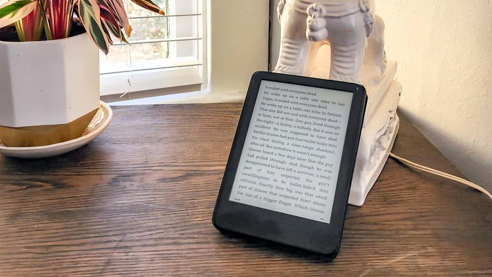 Amazon Kindle (2022) held in hand at a desk while open to an ebook page of text