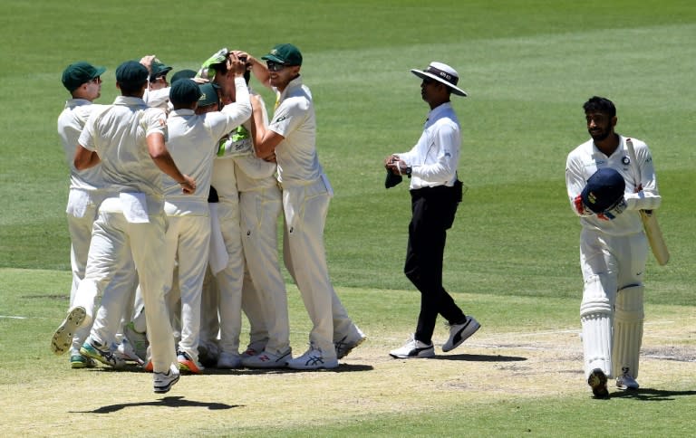 Australian players celebrate their victory as India's last batsman Jasprit Bumrah (R) walks off the field during the day five of the second Test cricket match between Australia and India in Perth on December 18, 2018