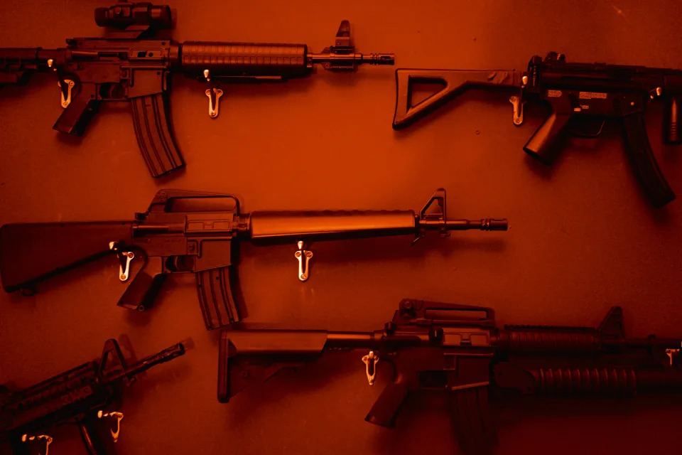 Several rifles hanging on a wall. 