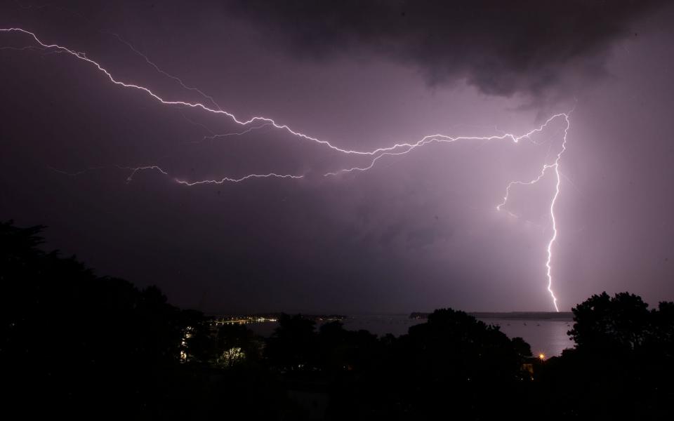 Lightning strikes over Poole harbour in Dorset as thunderstorms swept across parts of south west England - Credit: Martin Keene/PA