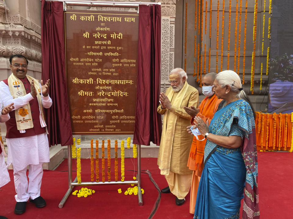 Indian Prime Minister Narendra Modi, center, unveils a plaque during the inauguration of Kashi Vishwanath Dham Corridor, a promenade that connects the sacred Ganges River with the centuries-old temple dedicated to Lord Shiva in Varanasi, India, Monday, Dec. 13, 2021. (AP Photo/Rajesh Kumar Singh)