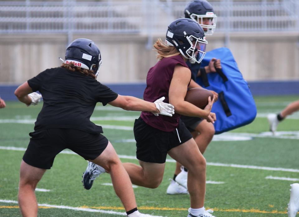 Petoskey quarterback Joe McCarthy takes off with the ball on a keeper through the defense during team drills in the first official practice of the season Monday at Northmen Stadium.