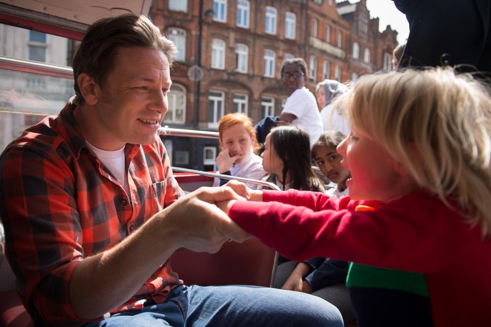 British Chef and television presenter Jamie Oliver plays with his son Buddy during an open-top bus tour of London to promote Food Revolution Day on May 15, 2015. Jamie Oliver is calling for a global campaign to put compulsory practical food eduction on the school curriculum of the G20 countries. AFP PHOTO / LEON NEAL        (Photo credit should read LEON NEAL/AFP/Getty Images)