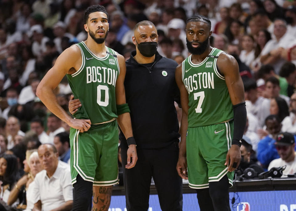 Boston Celtics head coach Ime Udoka speaks to Boston Celtics forward Jayson Tatum (0) and guard Jaylen Brown (7) during the second half of Game 1 of an NBA basketball Eastern Conference finals playoff series against the Miami Heat, Tuesday, May 17, 2022, in Miami. (AP Photo/Lynne Sladky)