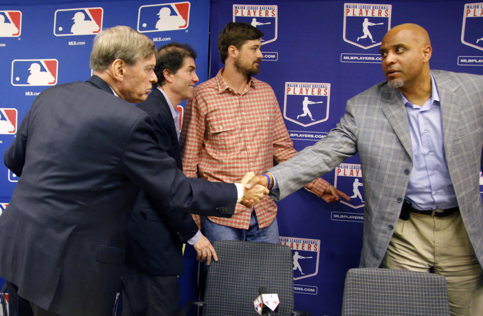 FILE - Major League Baseball Commissioner Bud Selig, left, shake hands with MLB Players Association Director of Players Relations Tony Clark, as MLBPA Executive Director Michael Weiner, second from left and Boston Red Sox's Andrew Miller, second from right, leaves after a press conference announcing a five-year collective bargaining agreement on Nov. 22, 2011. Getting a side to give back something it gained previously in collective bargaining can lead to difficult negotiations, which is why Major League Baseball has its first work stoppage in 26 years. (AP Photo/Bebeto Matthews, File)