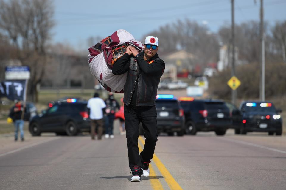 American Indian Movement member Lupe Jaso carries the drum across the bridge on Friday, April 5, 2024, along North Drive in Sioux Falls. Since the vehicles that were a part of the march could not continue with the crowd, the drum needed to be carried the rest of the way.