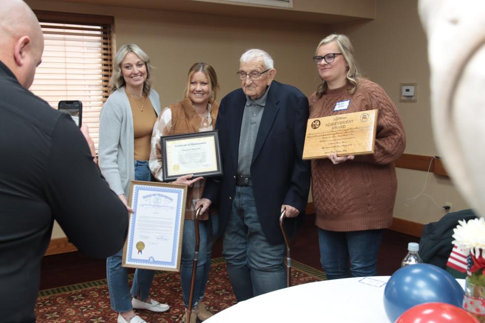 Longtime Lenawee County Republican Party chairman Ted Dusseau, second from right, poses for a photo with his grandaughters and several of the tributes he received during Ted Dusseau Day Saturday, Feb. 25, 2023, at the Carlton Lodge in Adrian. The event was put on by the county Republicans to thank Dusseau for his 30 years leading the party. Also pictured are, from left, Liz Spencley, Deanna Dusseau-Garno and Missy Shivley. Matt Garno is taking the photo.