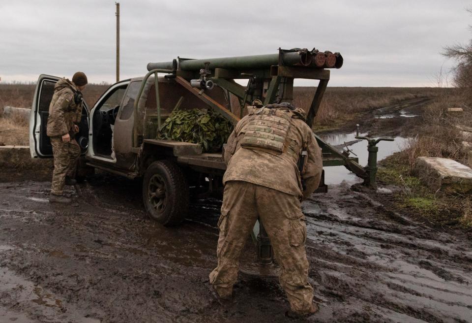 Ukrainian servicemen prepare to shoot from a self-made multiple rocket launcher on a frontline in Donetsk (EPA)