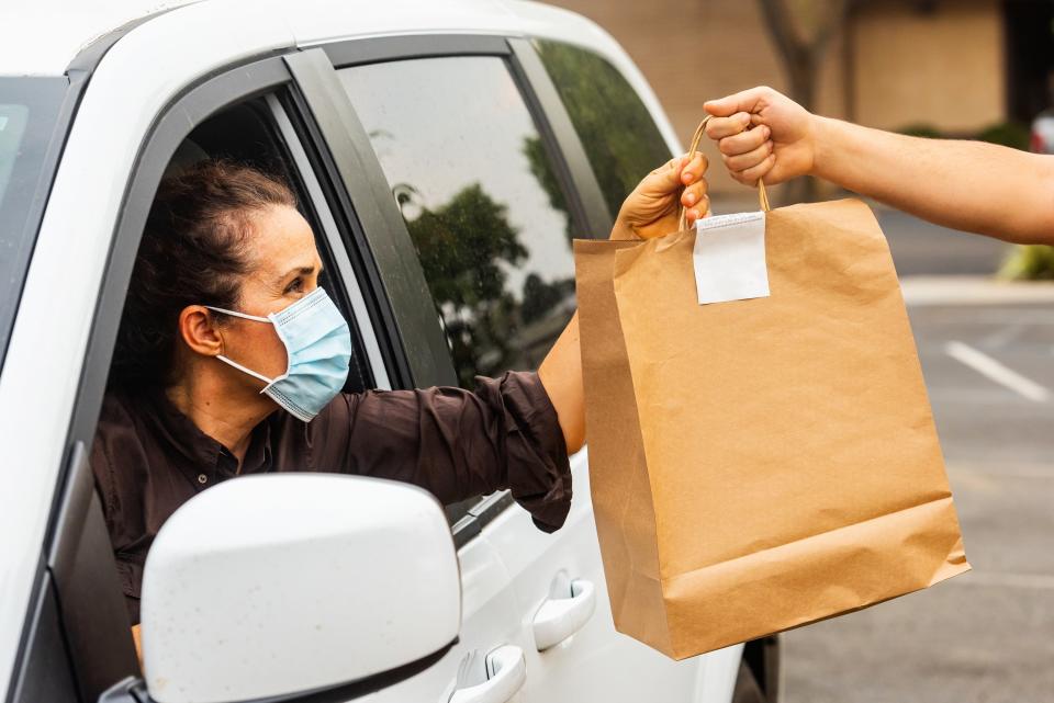 Person picking up a to-go order at a restaurant