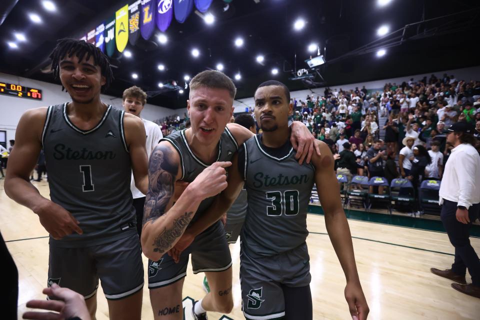 Stetson's Tristan Gross (1) and Treyton Thompson (42) celebrate with teammate Stephan Swenson (30) after Swenson hit a late 3-pointer as part of the Hatters' 88-87 win over Jacksonville in an ASUN semifinal on Thursday, March 7, 2024 in DeLand.