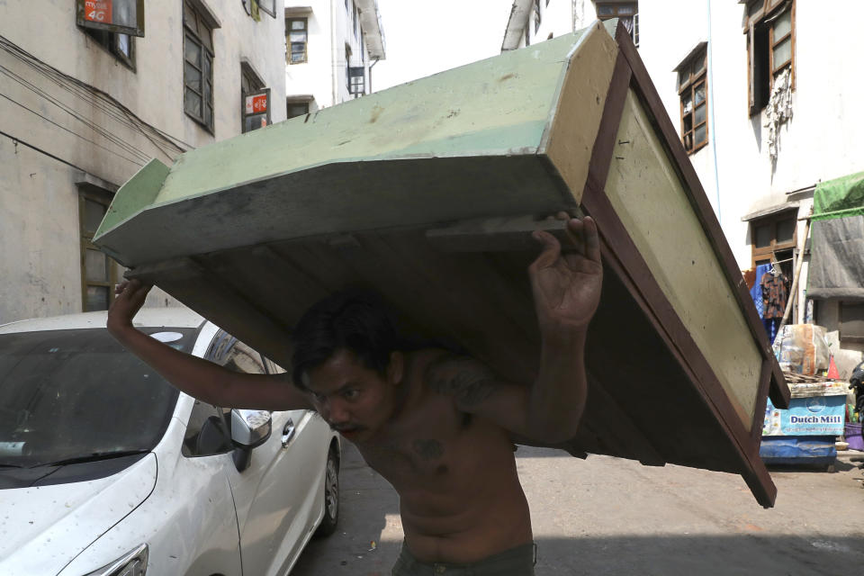 A state railway employee carries a piece of furniture after being evicted from his home Saturday, March 20, 2021, in Mandalay, Myanmar. State railway workers in Mandalay have been threatened with eviction to force them to end their support for the Civil Disobedience Movement (CDM) against military rule. (AP Photo)