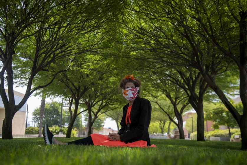 MENIFEE, CA - JUNE 24, 2020: Activists Albia Miller sits on the lush green lawn under a canopy of shade trees at the Menifee Valley Campus, where she normally spends many hours at the library nearby, but the library is now closed due to COVID-19 on June 24, 2020 in Menifee, California. She frequents most council meetings to oppose development projects in Riverside County and many times can be heard singing original songs during her opposition. But, due to COVID-19 she is unable to share her tunes.(Gina Ferazzi / Los Angeles Times)