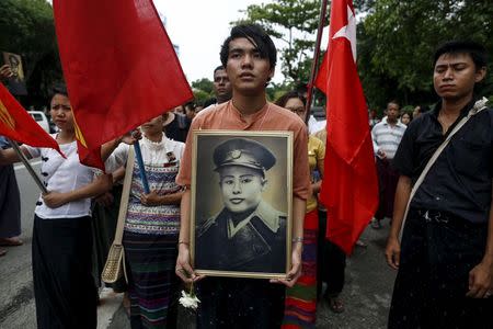 People hold General Aung San's portrait as they wait to pay respect during an event marking the anniversary of Martyrs' Day outside the Martyrs' Mausoleum in Yangon July 19, 2015. REUTERS/Soe Zeya Tun