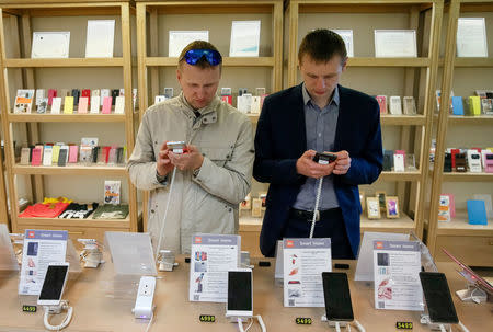 FILE PHOTO: Men try out Xiaomi smartphones at the company's store in central Kiev, Ukraine May 17, 2017. REUTERS/Valentyn Ogirenko/File Photo