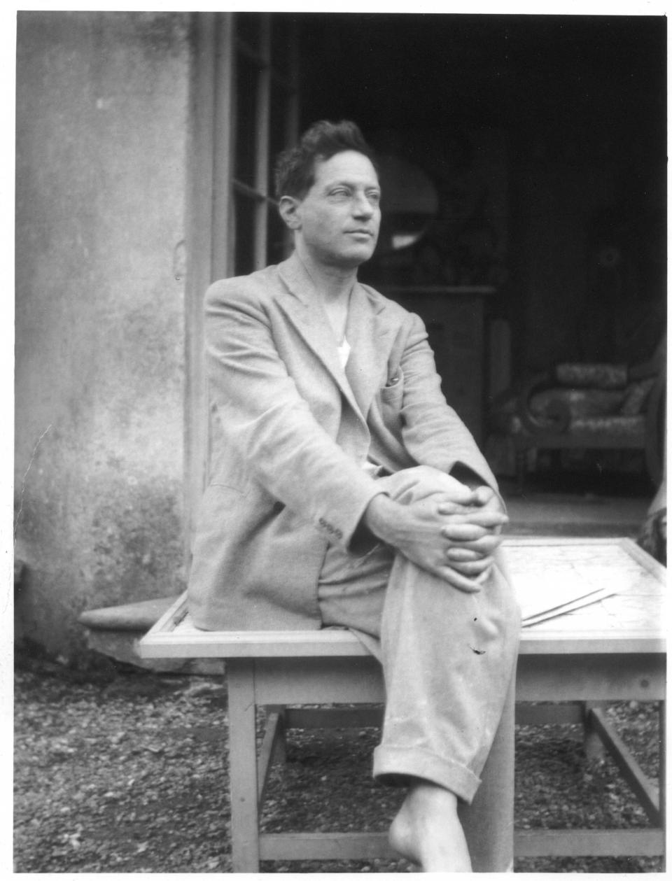 Duncan Grant outside the garden room at Charleston, 1933-35. - Credit: © The Charleston Trust