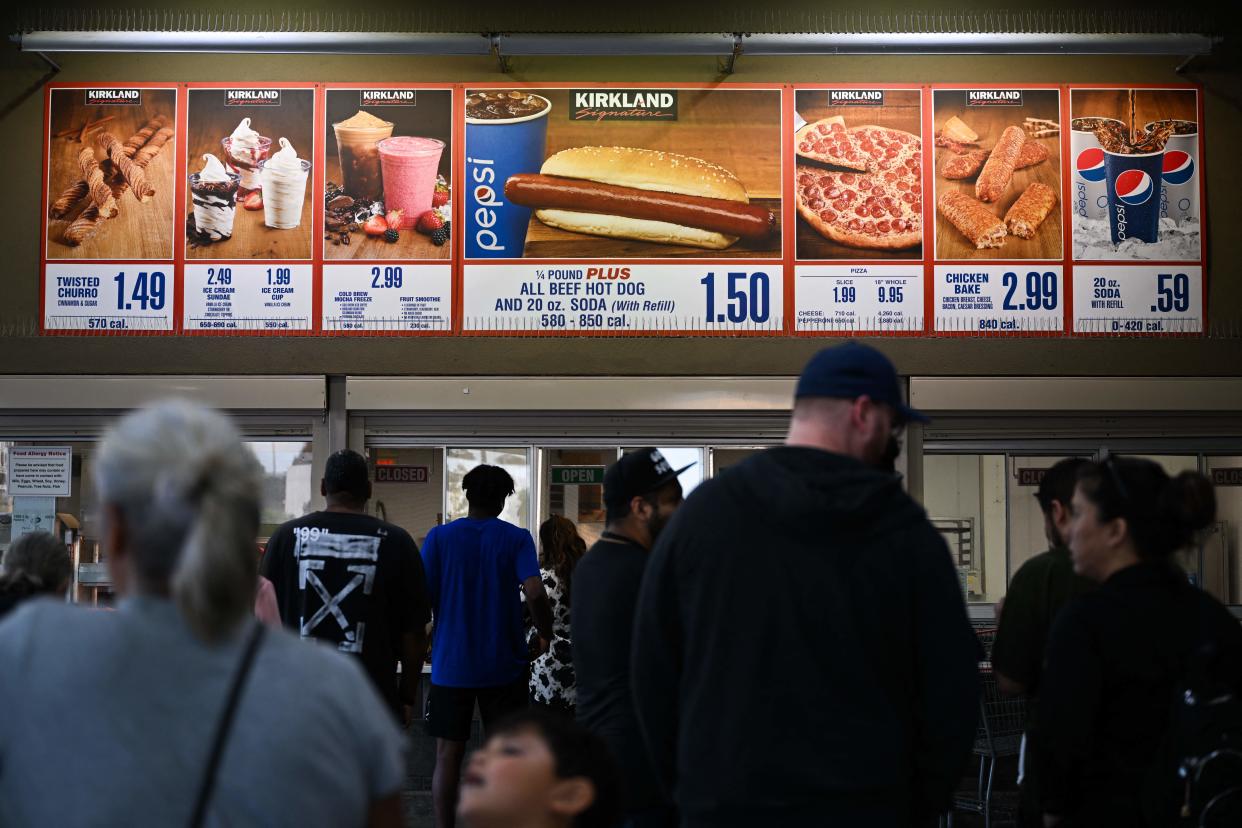 Customers wait in line to order below signage for the Costco Kirkland Signature $1.50 hot dog and soda combo, which has maintained the same price since 1985 despite consumer price increases and inflation, at the food court outside a Costco Wholesale Corp. store on June 14, 2022 in Hawthorne, California. (Photo by Patrick T. FALLON / AFP) (Photo by PATRICK T. FALLON/AFP via Getty Images)