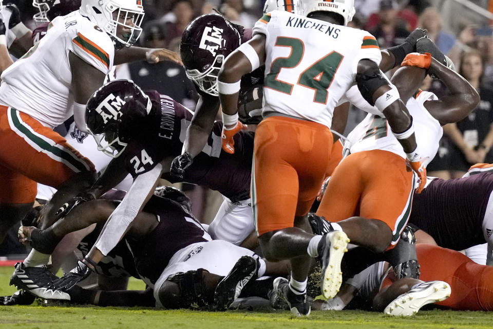 Texas A&M running back LJ Johnson Jr. (34) dives over the pile to score a touchdown against Miami during the first quarter of an NCAA college football game Saturday, Sept. 17, 2022, in College Station, Texas. (AP Photo/Sam Craft)