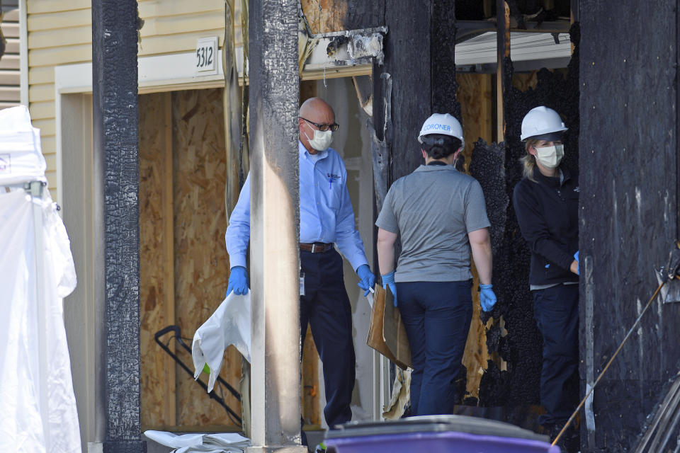 Investigators examine the remnants of a house fire that killed five people in suburban Denver on Wednesday, Aug. 5, 2020. Three people escaped the fire by jumping from the home's second floor. Investigators believe the victims were a toddler, an older child and three adults. Authorities suspect the fire was intentionally set. (AP Photo/Thomas Peipert)