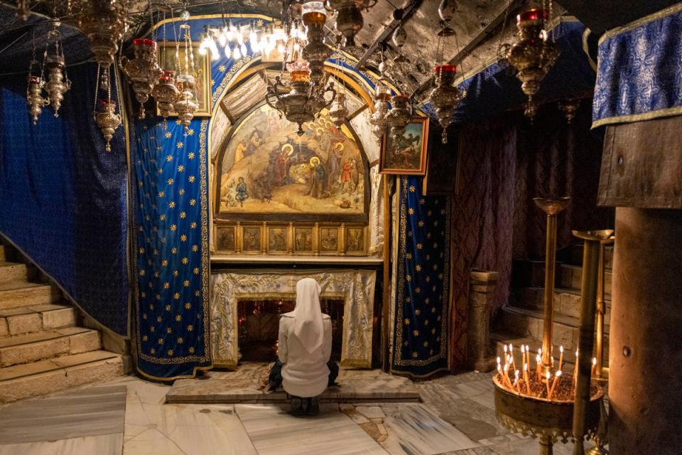 A nun prays in the grotto believed to be the spot where Jesus was born at the Church of the Nativity on 17 December in Bethlehem in the occupied West Bank. (Getty Images)