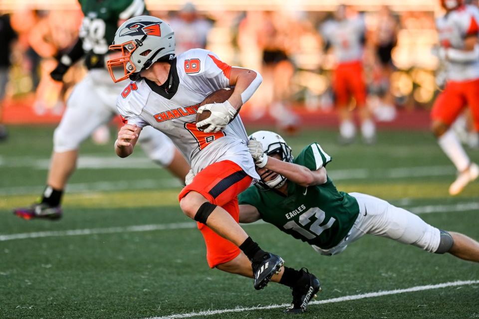 Charlotte's Cutler Brandt, left, breaks a tackle attempt by Olivet's Patrick Priesman during the second quarter on Friday, Aug. 26, 2022, at Olivet High School.