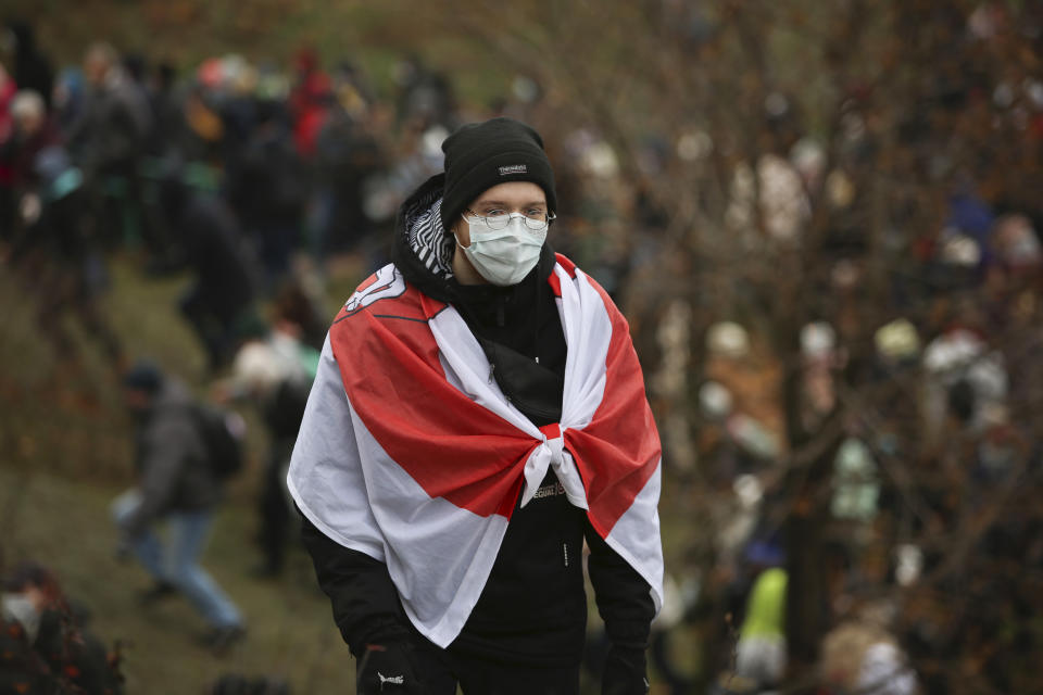 A demonstrator covering himself with an old Belarusian national flag stands during an opposition rally to protest the official presidential election results in Minsk, Belarus, Sunday, Nov. 15, 2020. A Belarusian human rights group says more than 500 people have been arrested in protests around the country calling for authoritarian President Alexander Lukashenko to step down. The Sunday demonstrations continued to wave of near-daily protests that have gripped Belarus since early August. (AP Photo)