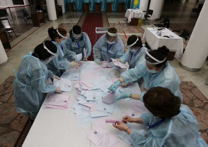 Members of a local electoral commission count ballots after polls closed during a parliamentary election in Almaty