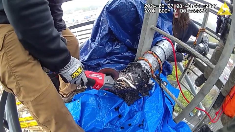 Crews cut a protester free from a tower crane at the construction site of Cop City, a new Atlanta public city training facility.