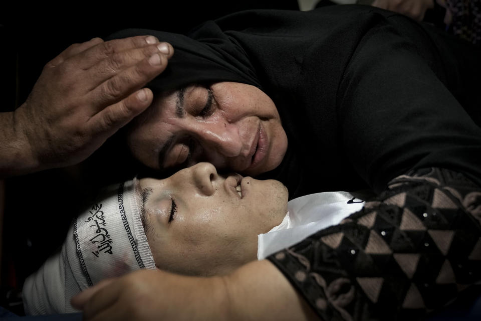 Palestinian relatives mourn over the body of Ahmad Awawda, 19, who was killed in clashes with Israeli troops near the city of Nablus the previous day, during his funeral in the West Bank city of Jenin, Sunday, Oct. 8, 2023. (AP Photo/Majdi Mohammed)