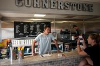 Dawson Padilla (L), owner of a protein shakes store, works behind the bar on May 5, 2020 in Stillwater, Oklahoma. - In the face of intimidation against employees and the threat of an armed attack by local residents wielding their individual liberties, the mayor of Stillwater had to give in: he gave up imposing the wearing of masks on customers in shops. This demand was included in a 21-page document that was supposed to accompany the gradual reopening of restaurants and shops from 1 May, as authorized by the state of Oklahoma. "About three and a half hours after the law came into effect" of the text, "we started receiving calls from stores claiming that employees were being threatened and insulted, and threatened with physical violence," said Norman McNickle, the city's director of services. (Photo by Johannes EISELE / AFP) (Photo by JOHANNES EISELE/AFP via Getty Images)