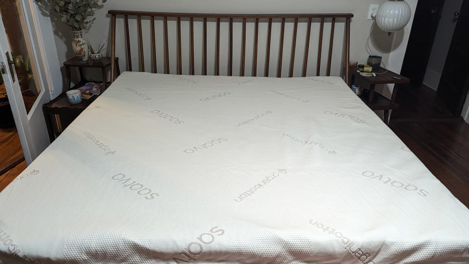 The Saatva Graphite Memory Foam Mattress Topper on a bed