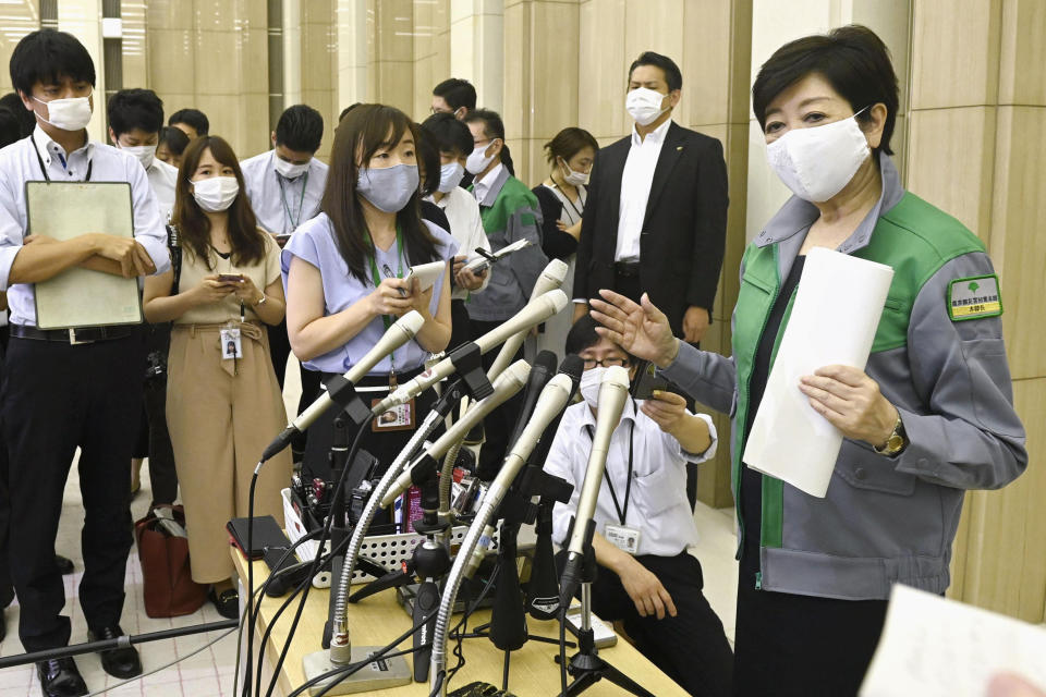 Tokyo Governor Yuriko Koike, right, speaks to media at the Metropolitan Government Office Thursday, July 9, 2020, in Tokyo. Tokyo confirmed more than 220 new cases Thursday, exceeding its record daily increase from mid-April and prompting concerns of widening of the infections. Tokyo’s more than 7,000 cases are about one-third of Japan's total. “It’s a wake-up call,” Gov. Koike told reporters. “We need to use extra caution against the further spread of the infections.”(Kyodo News via AP)