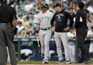 New York Yankees manager Aaron Boone, second from right, and a trainer, right, talk with Matt Carpenter after he fouled a ball off his ankle against the Seattle Mariners during the first inning of a baseball game, Monday, Aug. 8, 2022, in Seattle. He was replaced in the lineup after his at bat. (AP Photo/John Froschauer)