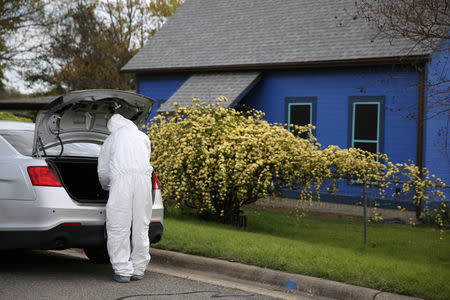 A law enforcement member is seen down the street from the home where Austin serial bomber Mark Anthony Conditt lived in Pflugerville, Texas, U.S., March 22, 2018. REUTERS/Loren Elliott