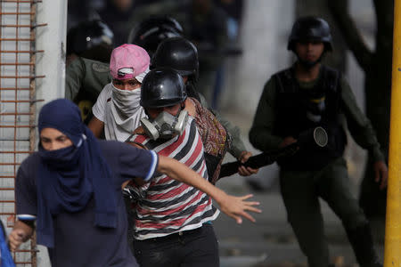 FILE PHOTO: Demonstrators run away from riot security forces at a rally during a strike called to protest against Venezuelan President Nicolas Maduro's government in Caracas, Venezuela, July 27, 2017. REUTERS/Marco Bello/File Photo