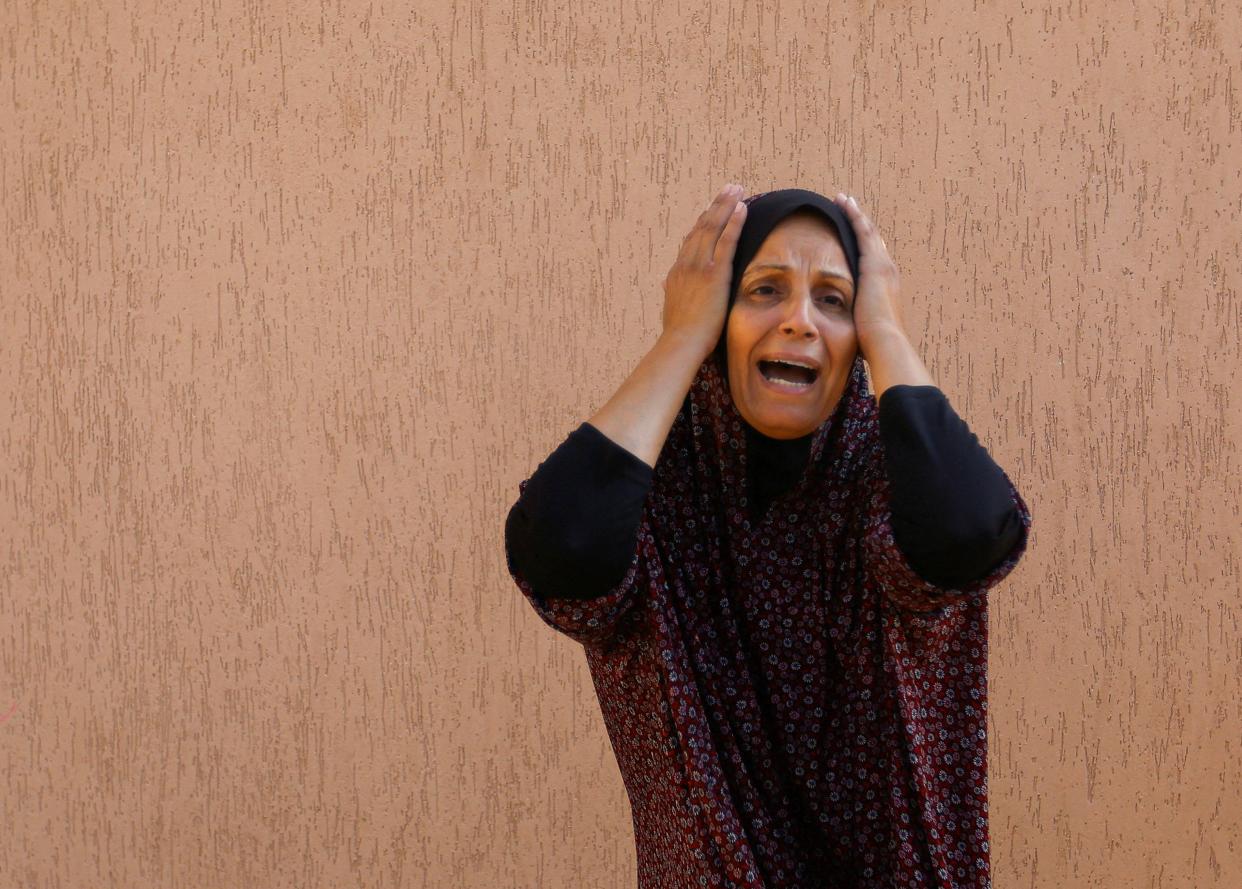 A Palestinian woman reacts in the aftermath of Israeli strikes (REUTERS)