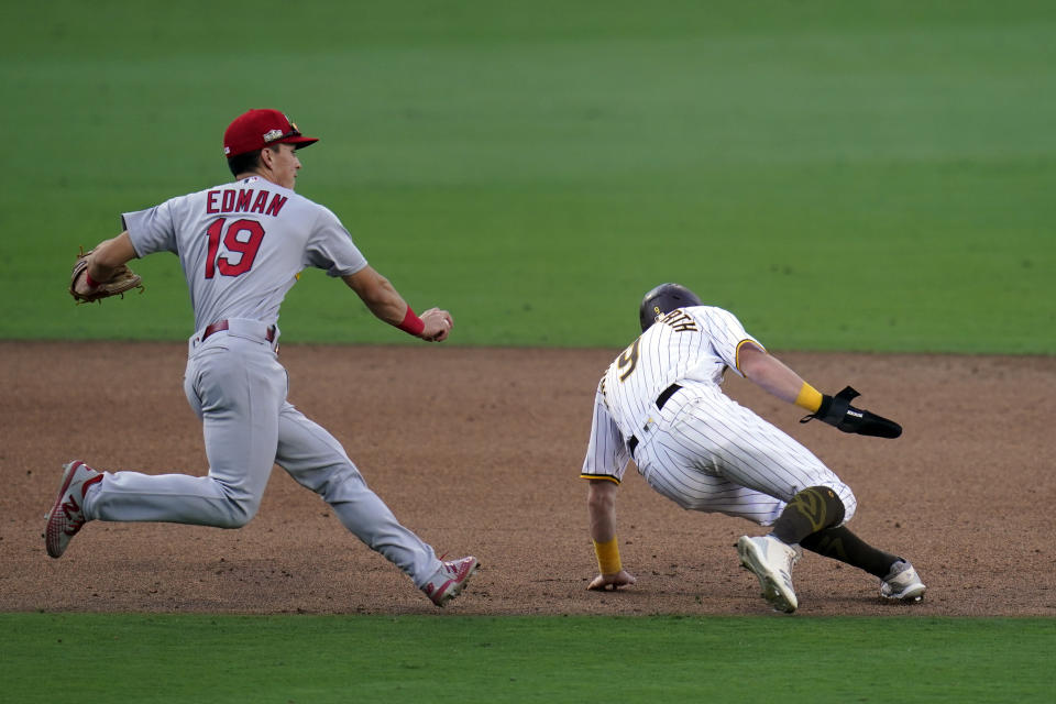 St. Louis Cardinals third baseman Tommy Edman, left, tags out San Diego Padres' Jake Cronenworth to complete a double play during the sixth inning of Game 1 of a National League wild-card baseball series Wednesday, Sept. 30, 2020, in San Diego. Austin Nola was out on a sacrifice fly and Tommy Pham scored. (AP Photo/Gregory Bull)