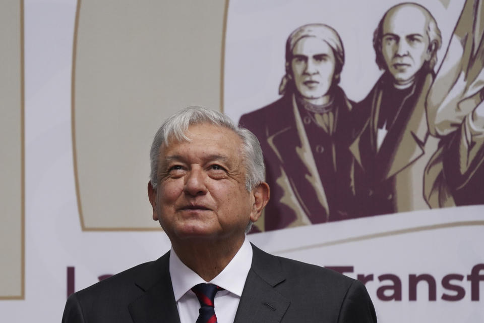 Mexican President Andres Manuel Obrador smiles as people applaud after the playing of the national anthem at the end of an event where he delivered a speech on economic figures, in Mexico City, Tuesday, April 12, 2022. (AP Photo/Marco Ugarte)