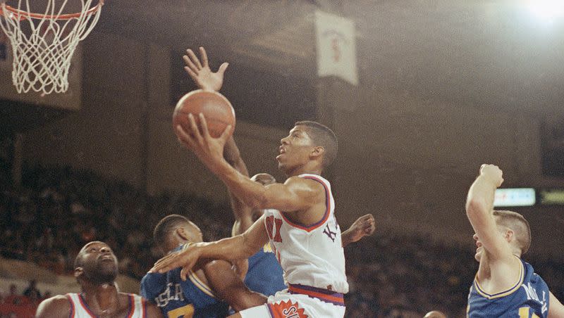 In this Nov. 7, 1990 file photo, Phoenix Suns’ guard Kevin Johnson uses his hand to help him over Golden State Warriors Alton Lister to score. On Nov. 10, 1990, the Phoenix Suns set and broke multiple NBA and franchise records, scoring an NBA record 107 points in the first half, 
