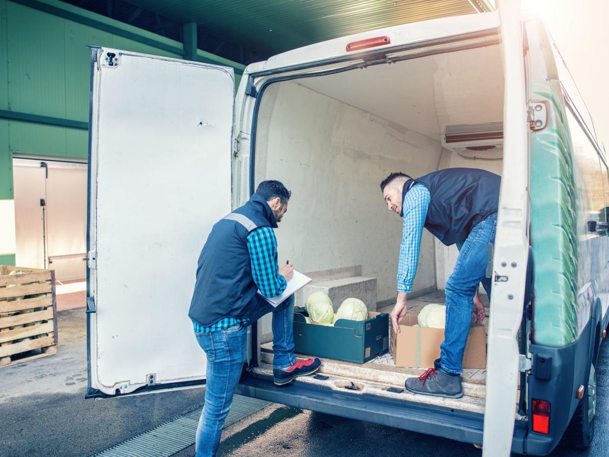 Men is loading boxes with vegetables in van