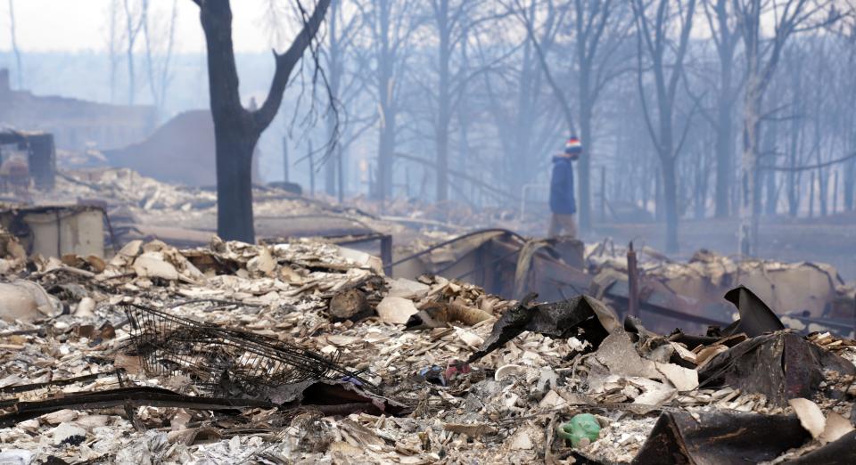 Brendan Conroy walks through the rubble of the family's destroyed home in Louisville, Colorado, following devastating wildfires that tore through the town Dec. 30. Authorities are actively investigating what caused the blaze.