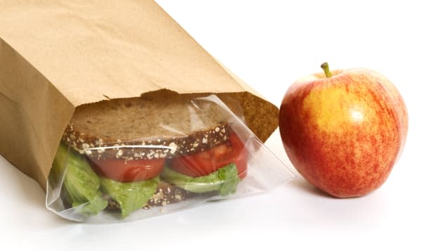 Sandwich in a bag with an apple on the side