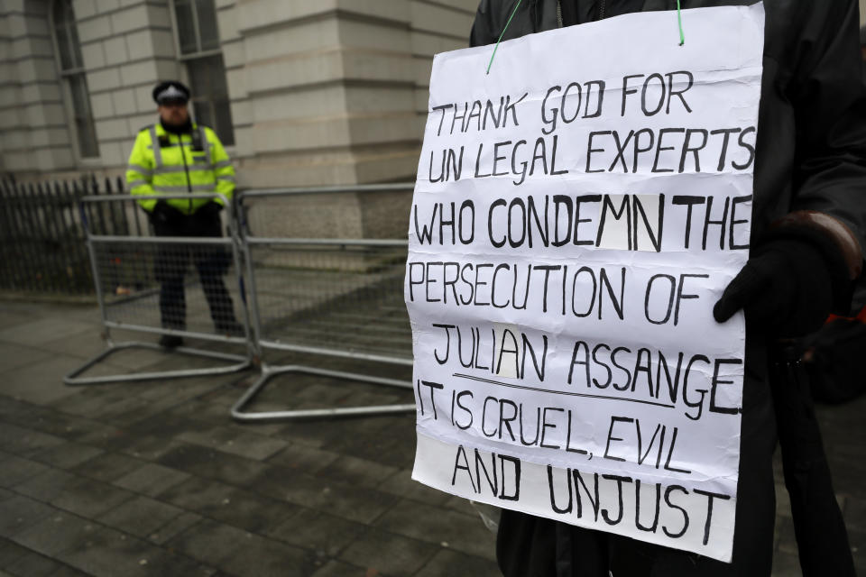 A demonstrator supporting Julian Assange holds a banner outside Westminster Magistrates Court in London, Thursday, Jan. 23, 2020. Assange is scheduled to be presented before the court in Westminster by videolink, for a case management hearing ahead of his full extradition trial which begins on Feb. 24. at Woolwich Crown Court. (AP Photo/Kirsty Wigglesworth)