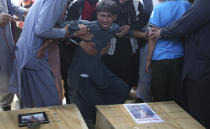 A relative wails near the coffins of victims of the Dubai City wedding hall bombing during a mass funeral in Kabul, Afghanistan, Sunday, Aug.18, 2019. The deadly bombing at the wedding in Afghanistan's capital late Saturday that killed dozens of people was a stark reminder that the war-weary country faces daily threats not only from the long-established Taliban but also from a brutal local affiliate of the Islamic State group, which claimed responsibility for the attack. (AP Photo/Rafiq Maqbool)