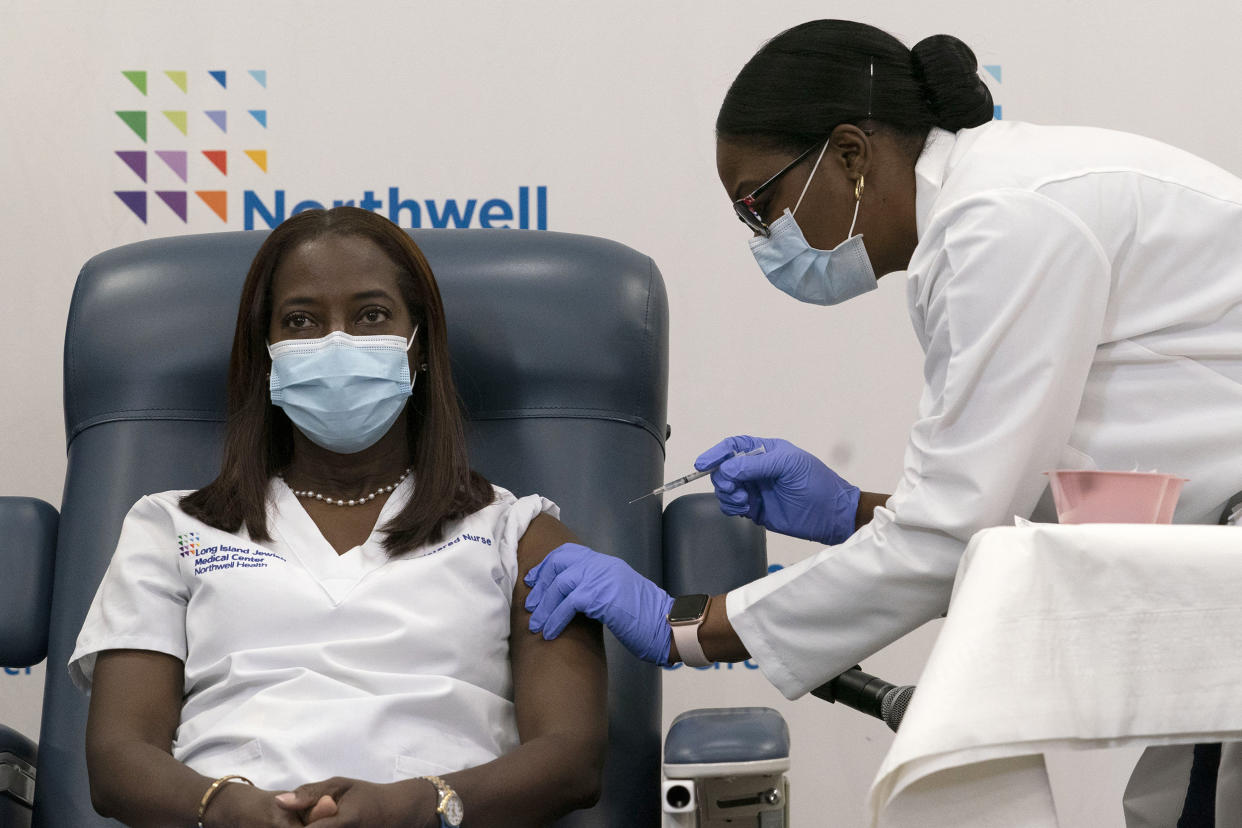Sandra Lindsay is inoculated with the Pfizer-BioNTech COVID-19 vaccine by Dr. Michelle Chester, at Long Island Jewish Medical Center in Queens, N.Y., on Dec. 14, 2020. (Mark Lennihan / AP Pool file)